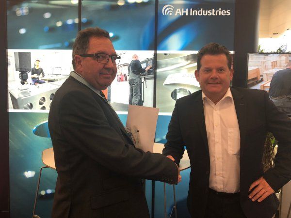 Medejer og CMO Adrian Willetts, AH Industries, og administrerende direktør og ejer Achim Oebel, Multigear, giver hånd på aftalen i forbindelse med indgåelsen på den igangværende WindEnergy Hamburg 2018. (Foto: AH Industries)